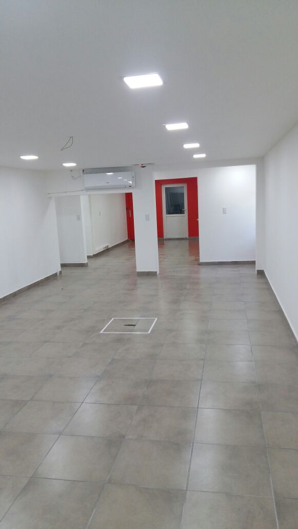 Sala terminada con piso cerámico y puertas al fondo