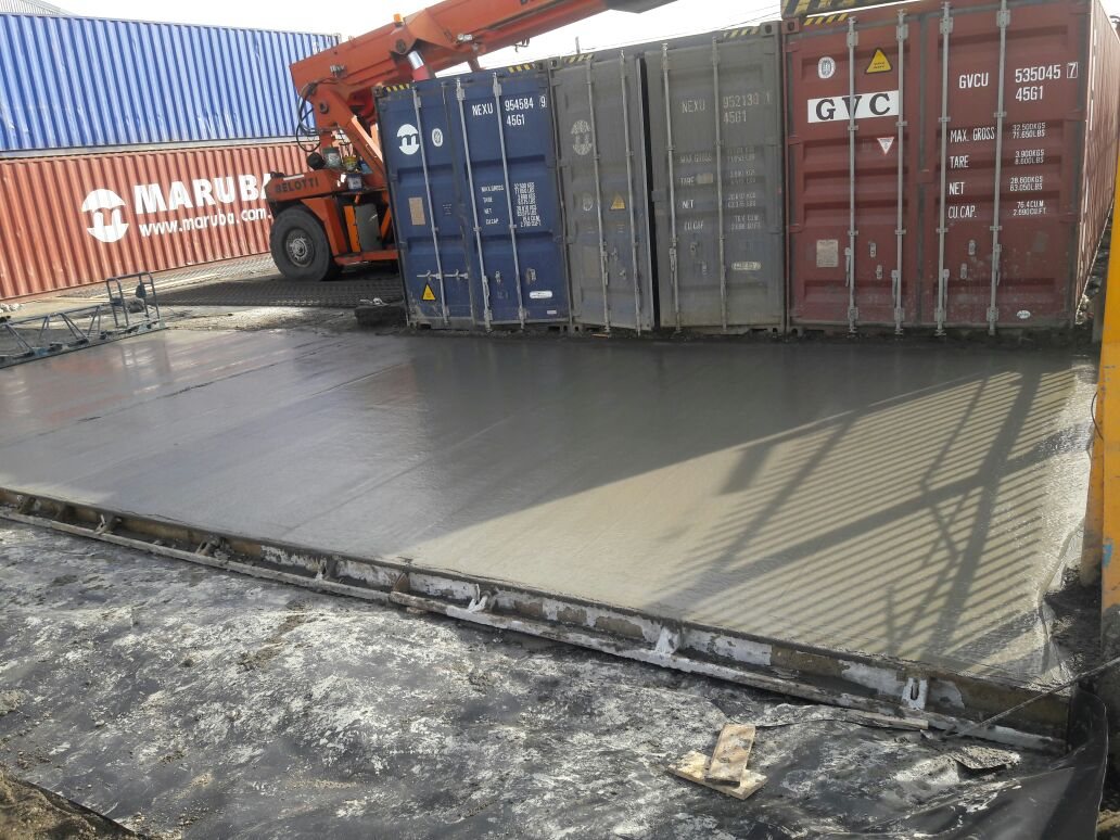Paño de hormigón terminado junto a los contenedores