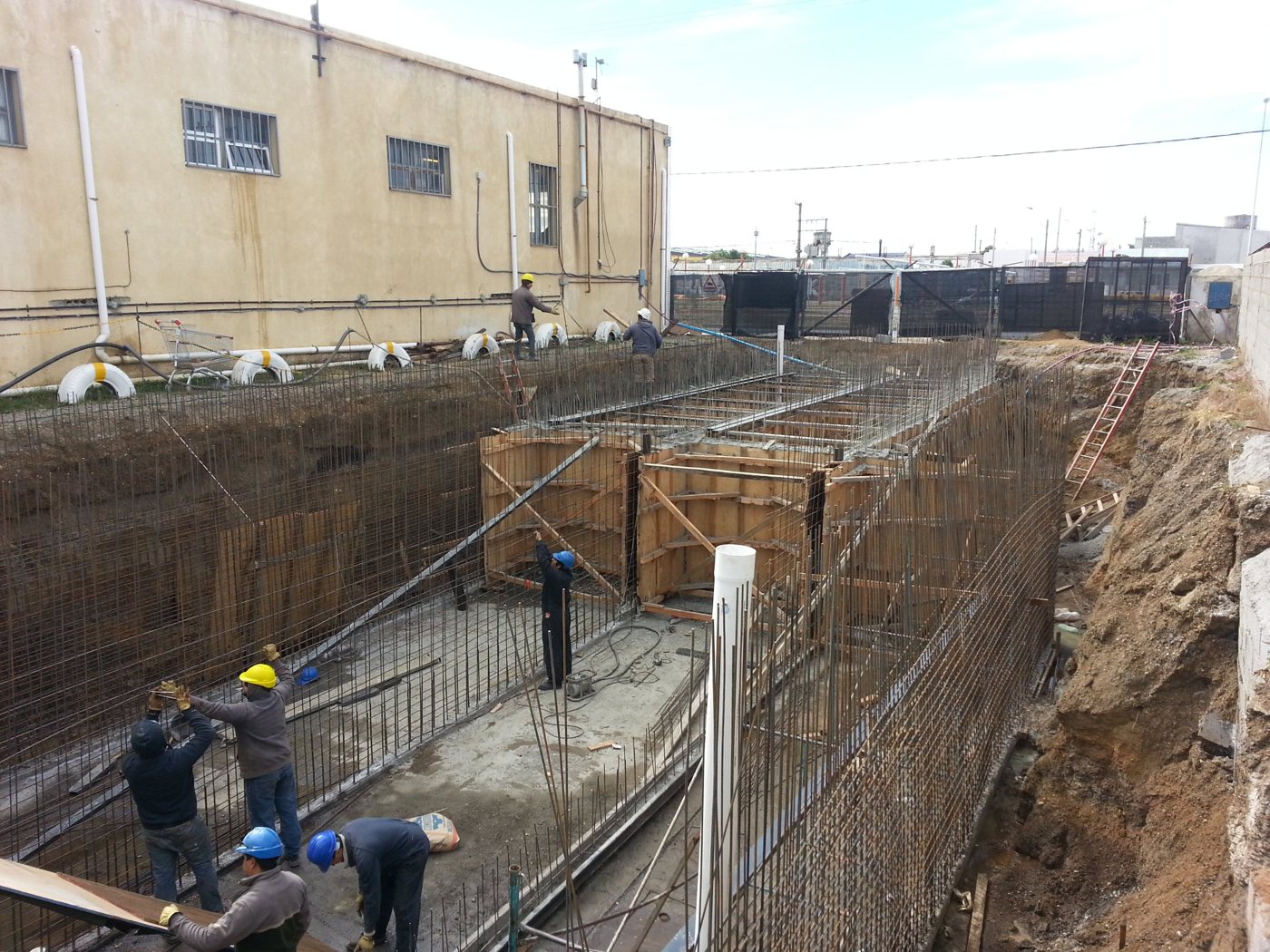 Cuadrilla armando los muros de hormigón dentro de la excavación