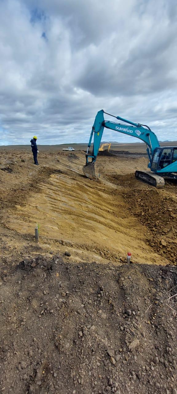 Excavadora perfilando un talud