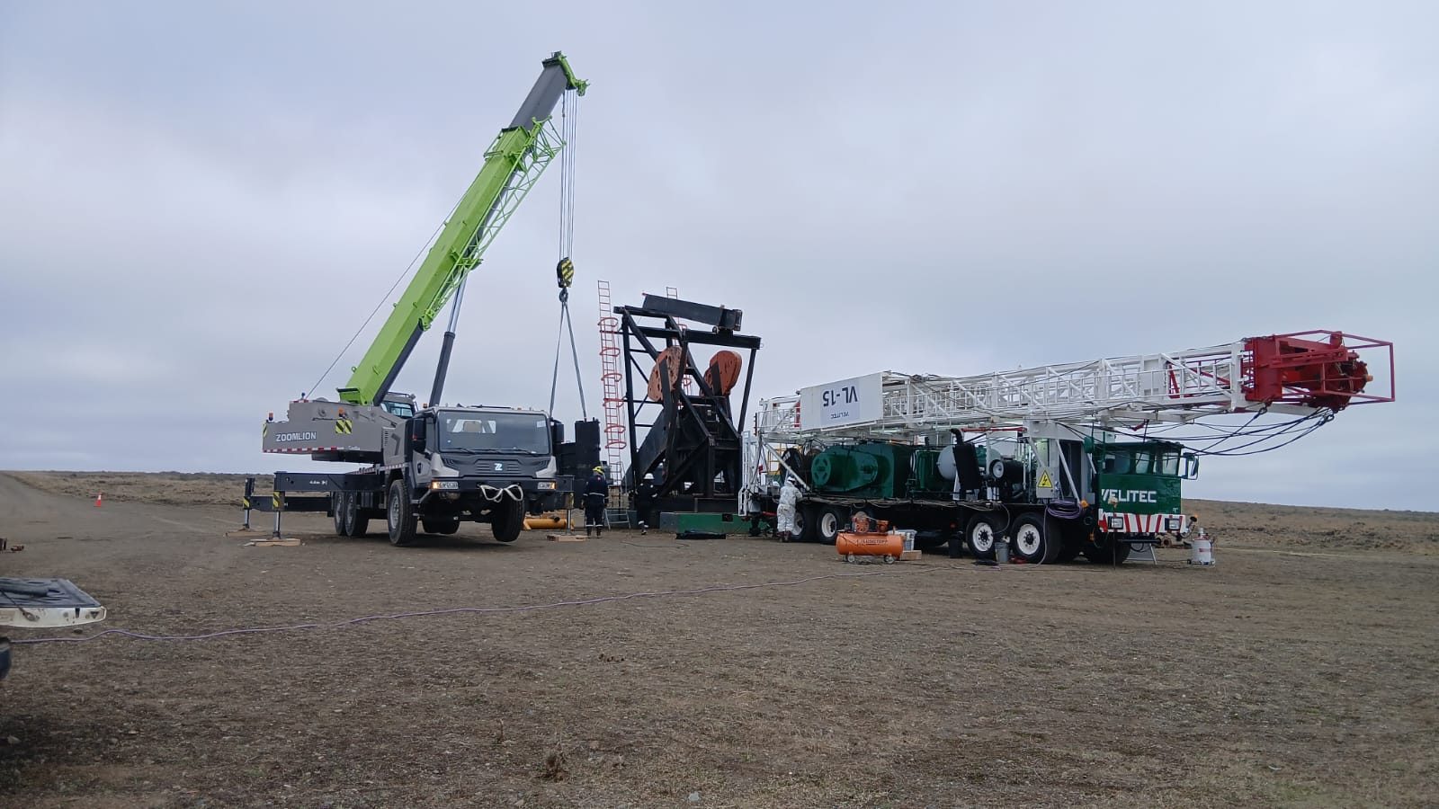 Grúa de Constructora Patagonia trabajando junto a un equipo de torre en yacimiento