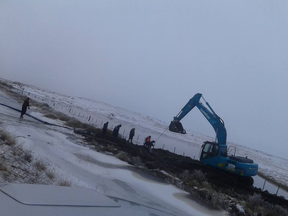 Excavadora trabajando sobre el caño troncal con nieve
