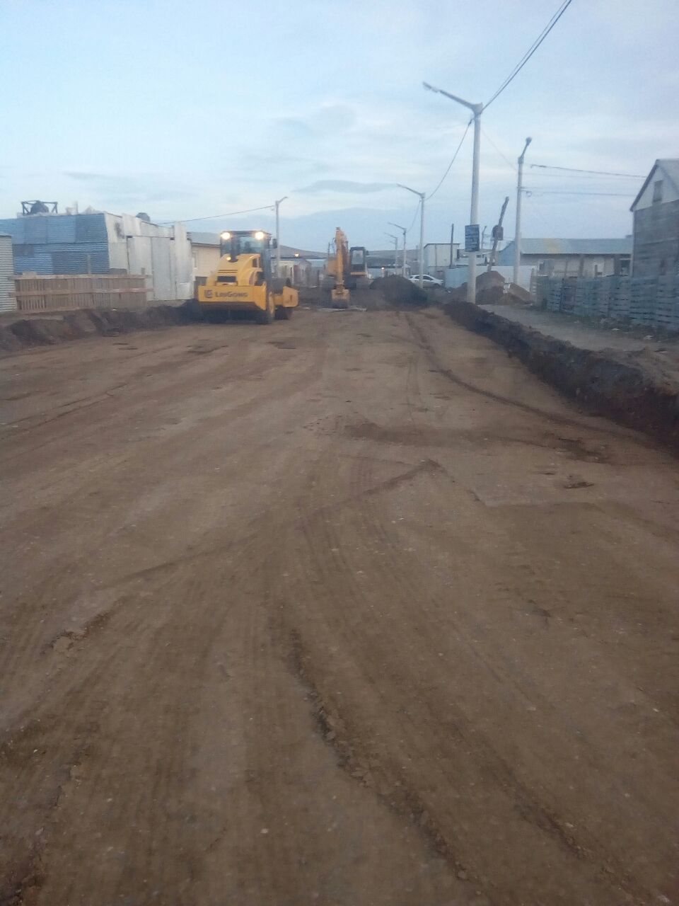 Rodillo y excavadora trabajando en la calle