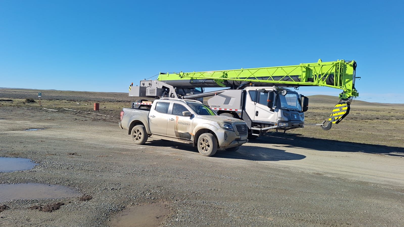 Grúa y camioneta de la empresa en el campo