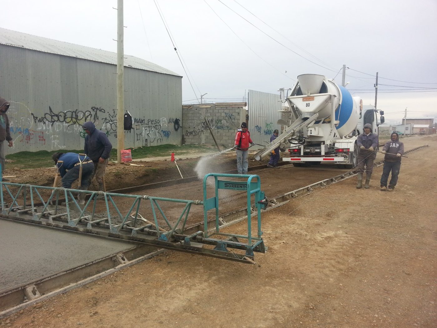 Mixer descargando y regla vibratoria en la calle