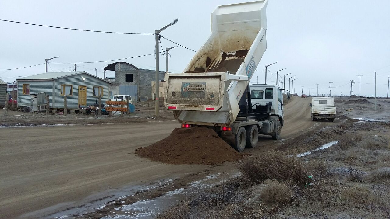 Camión volcador de la empresa descargando suelo en una calle del barrio