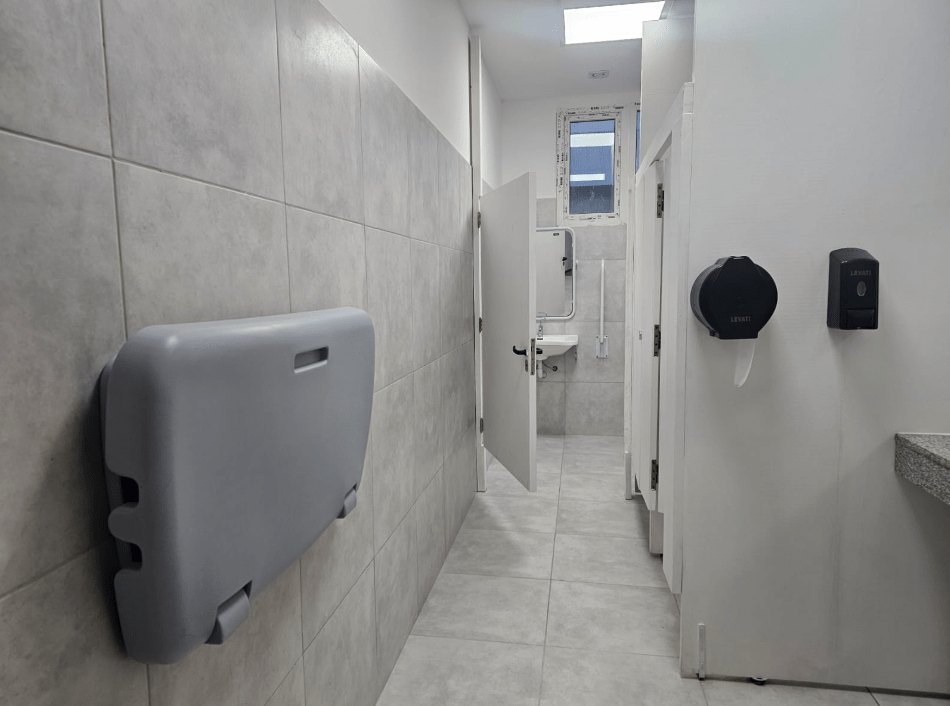 Baño terminado con cambiador y cabinas