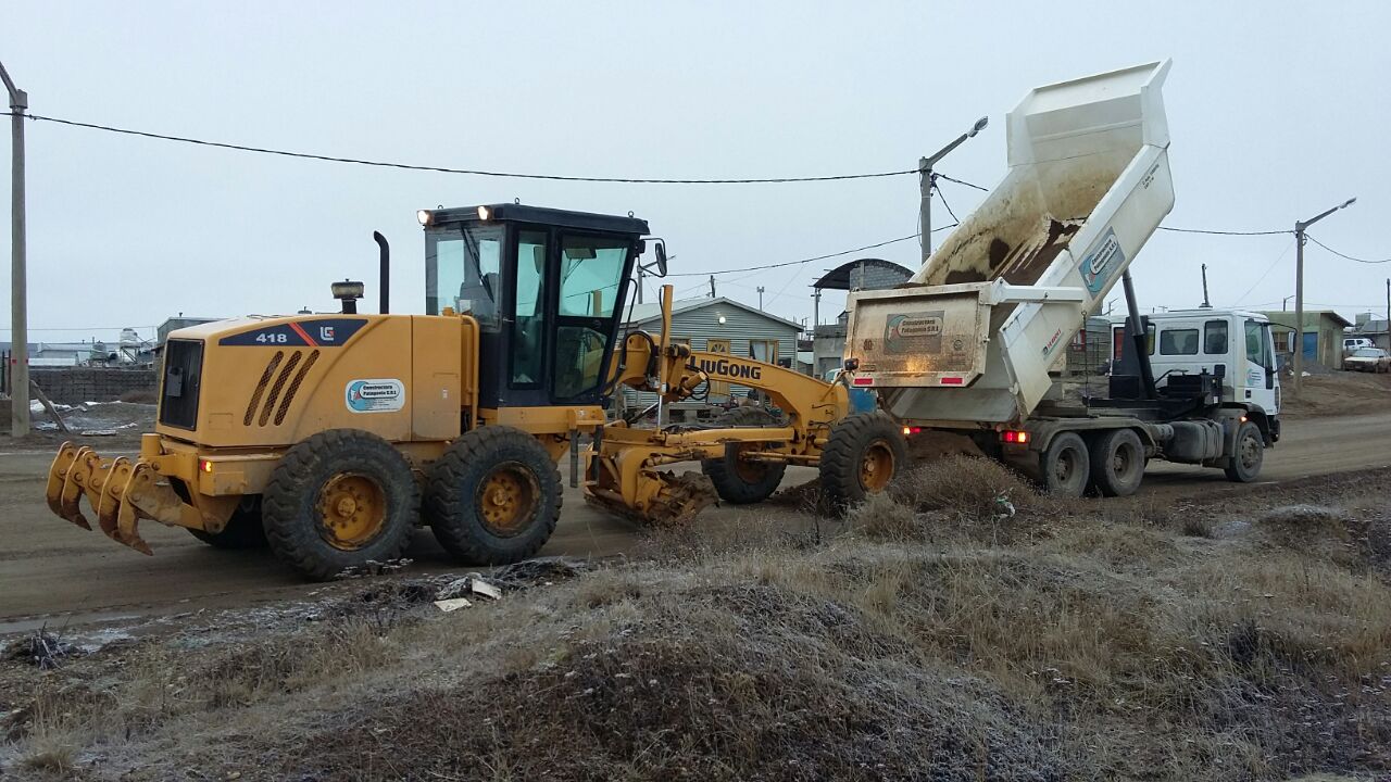 Motoniveladora LiuGong 418 y camión volcador trabajando en una calle de tierra