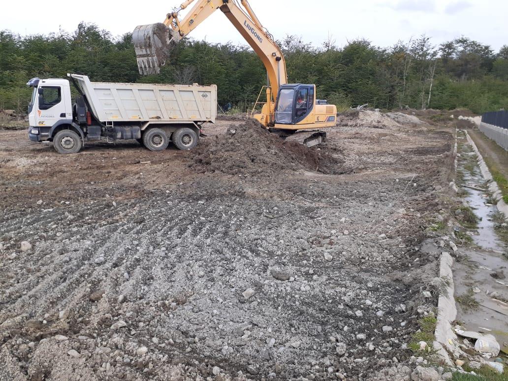Excavadora cargando un volcador junto al bosque
