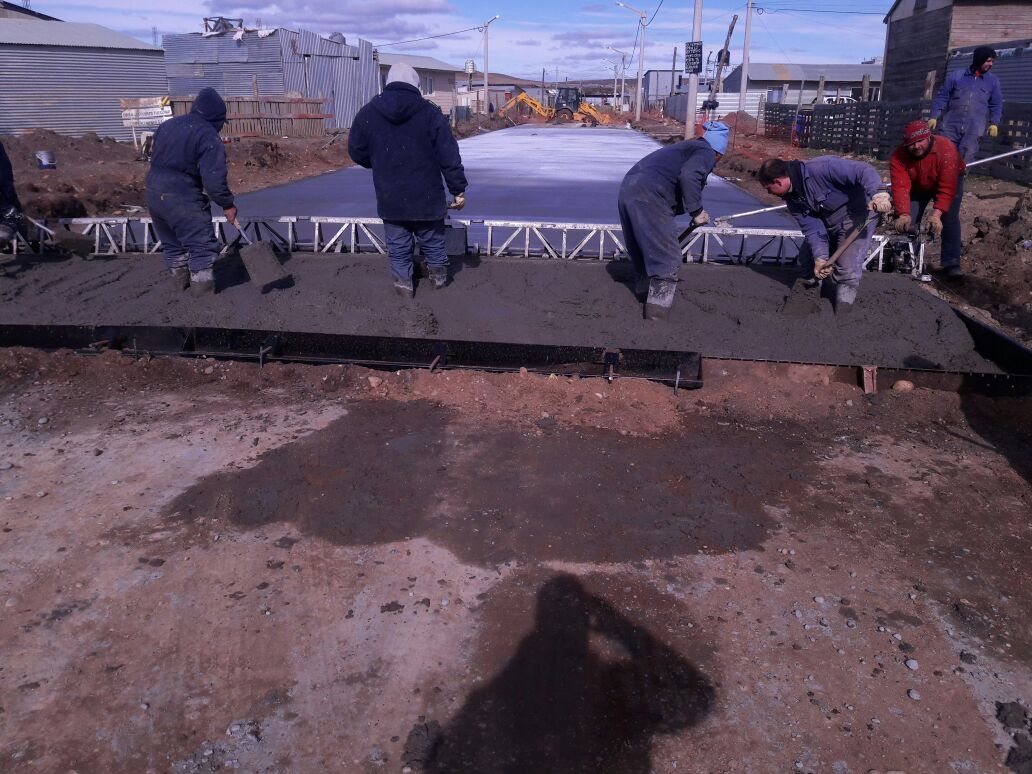 Cuadrilla distribuyendo el hormigón delante de la regla