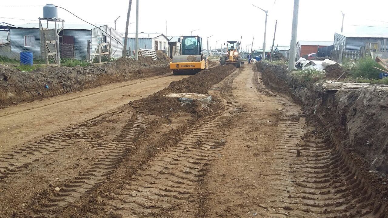 Rodillo y motoniveladora avanzando sobre la calle en obra