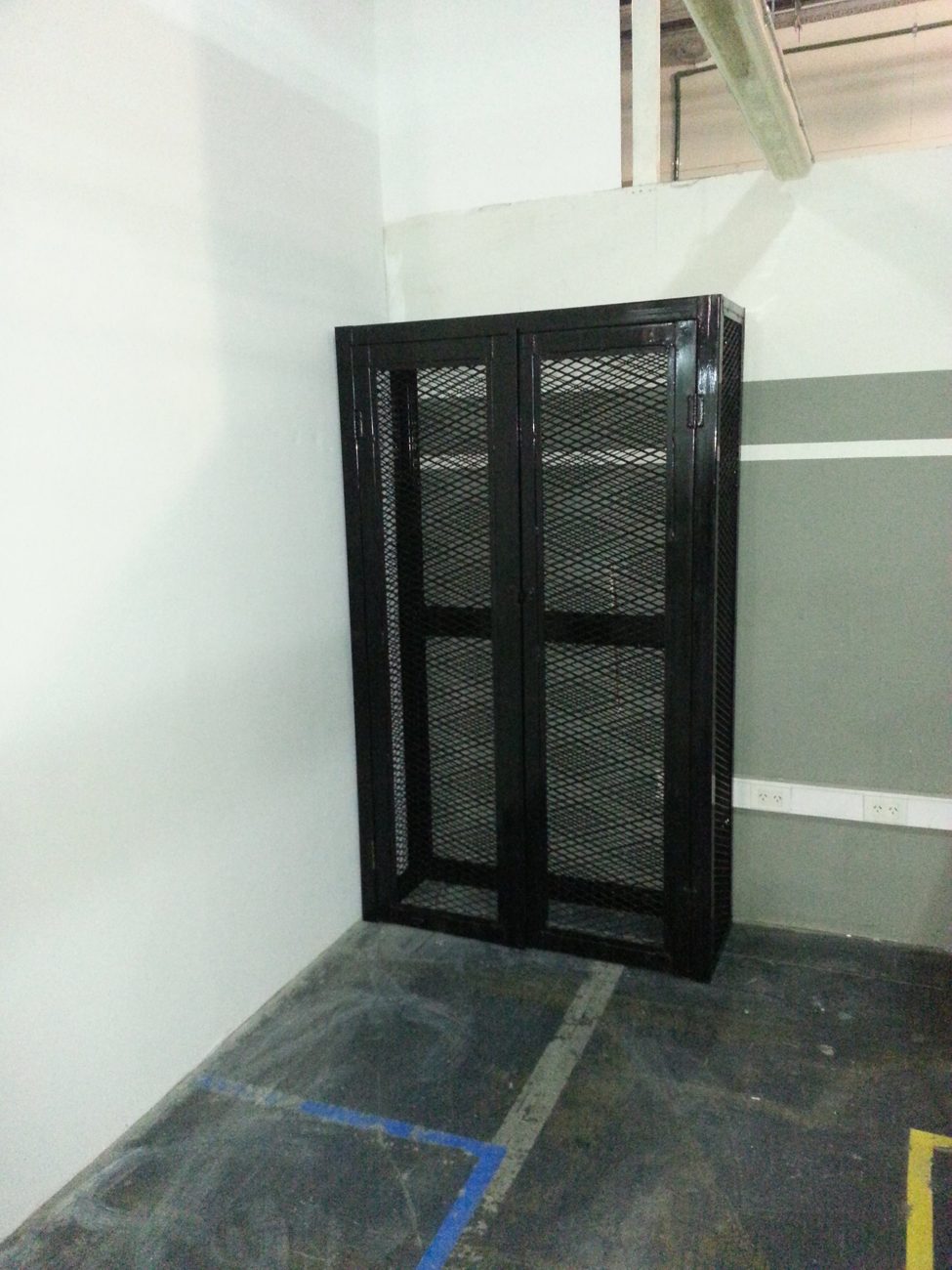Gabinete metálico de rejilla junto al pasadizo