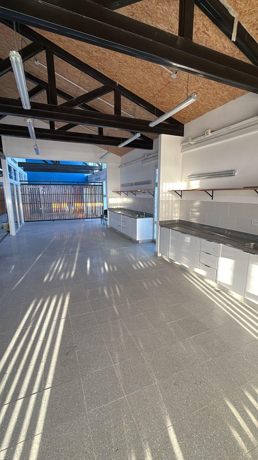 Sala principal con cocina y luz entrando por la celosía