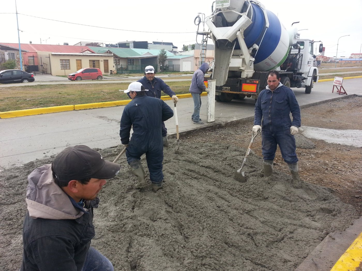 Cuadrilla distribuyendo hormigón desde un camión mixer en un bacheo